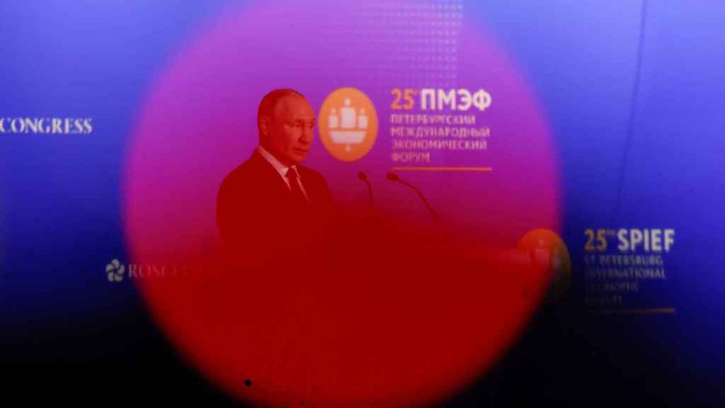 Le président russe Vladimir Poutine est vu à travers la lumière d'une caméra de télévision pendant une session du Forum économique international de Saint-Pétersbourg (SPIEF).