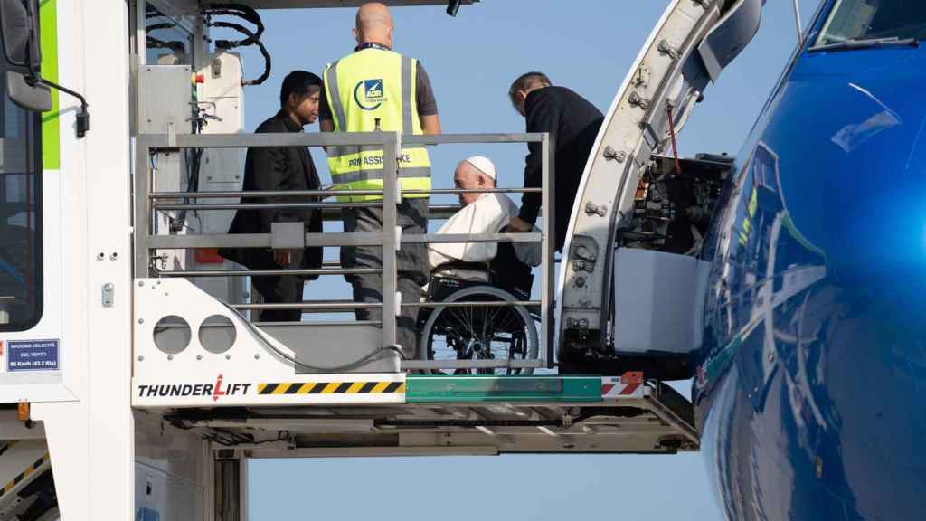 Le Pape François entrant dans l'avion en fauteuil roulant.