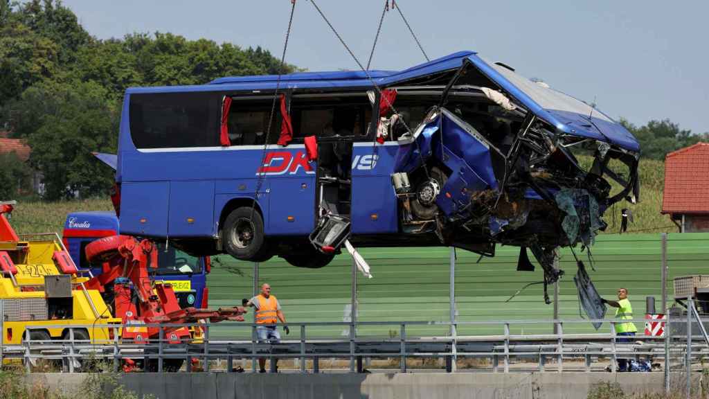 Une grue ramasse le bus après l'accident à Zagreb, samedi.