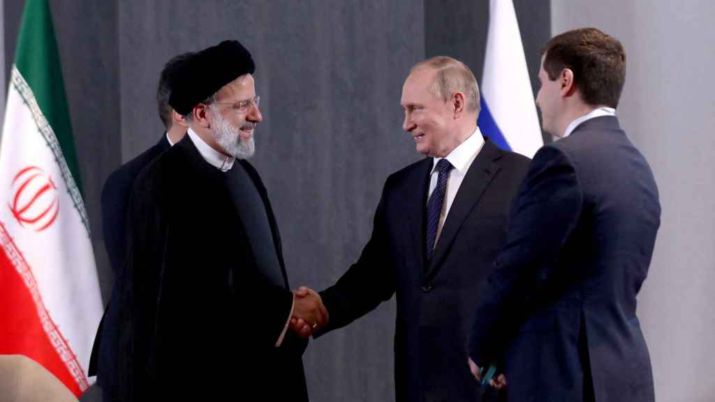 Le président russe Vladimir Poutine serre la main du président iranien Ebrahim Raisi.