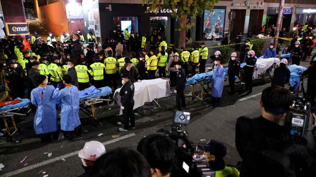 Une file de brancards et de médecins s'occupent des blessés dans une rue de Séoul après la tragédie de samedi.