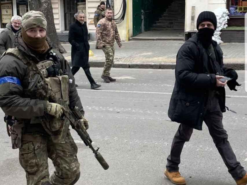 Bernard-Henri Lévy se promène dans les rues d'Odessa avec plusieurs soldats ukrainiens.