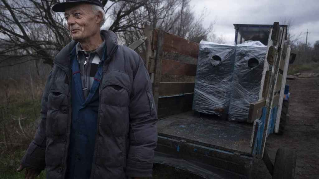 Sasha, debout à côté de la remorque où des bénévoles ont chargé des chaudières portables pour ses maisons et celles d'autres habitants de Tsupivka.