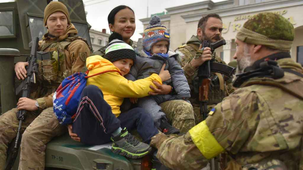 Un soldat ukrainien embrasse des enfants sur la place centrale de Kherson, en Ukraine.