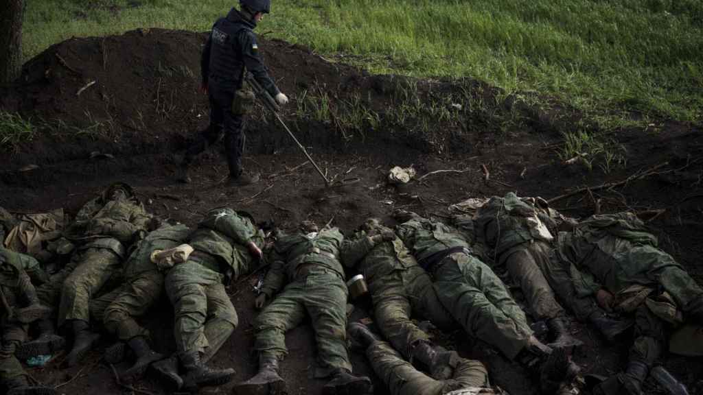 Un soldat ukrainien cherche des mines parmi les corps de 11 soldats russes.