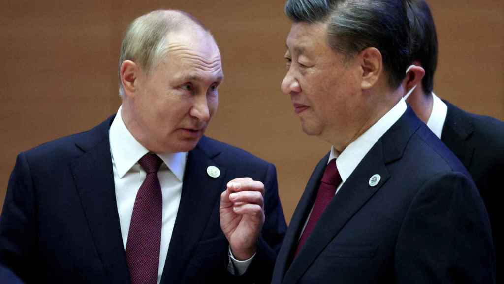 Le président russe Vladimir Poutine s'entretient avec le président chinois Xi Jinping avant une réunion.
