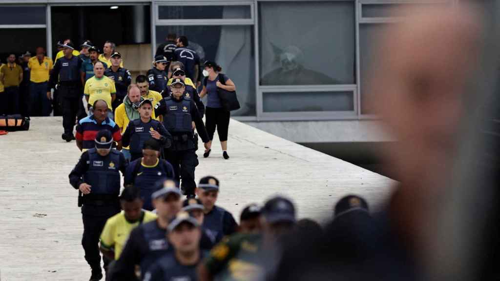 Les forces de sécurité arrêtent des partisans de l'ancien président brésilien Jair Bolsonaro lors d'une manifestation contre le président Luiz Inácio Lula da Silva devant le palais du Planalto à Brasilia .