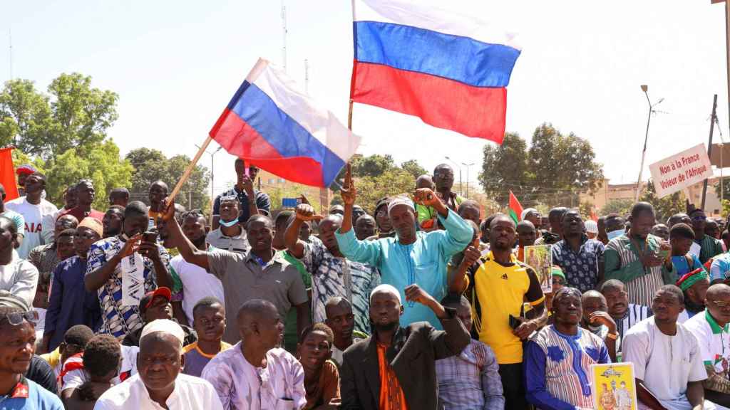 Des manifestants agitant le drapeau russe avant la retraite française.