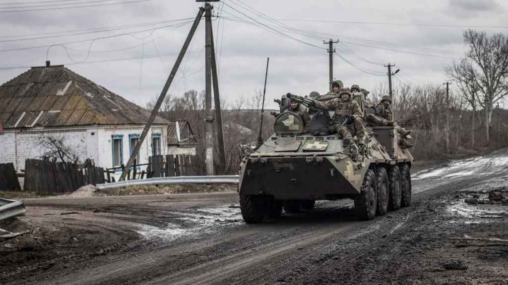 Des militaires ukrainiens montent sur un véhicule blindé de transport de troupes (APC), alors que l'attaque de la Russie contre l'Ukraine se poursuit, dans le village de Torske, région de Donetsk, Ukraine, le 30 décembre.